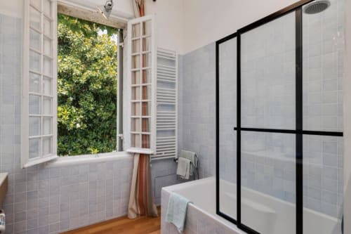 Salle de bains moderne du gîte Le Clos de la Chapelle aux Petits Toits, Galgon, avec douche ouverte et vue sur le jardin