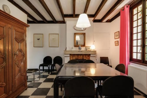 Salle à manger élégante du gîte Le Clos de la Chapelle aux Petits Toits, Galgon, avec poutres apparentes et cheminée.