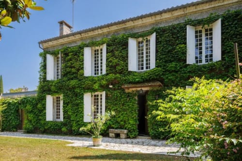 Maison de charme couverte de lierre aux Petits Toits à Galgon, avec volets blancs et jardins raffinés