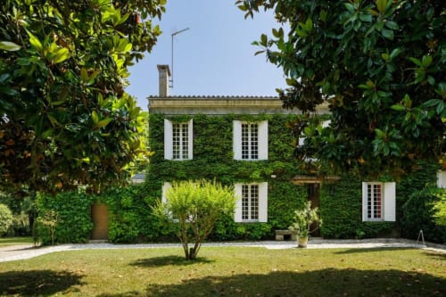 Chaumière aux façades couvertes de lierre aux Petits Toits à Galgon, fenêtres blanches et jardin luxuriant