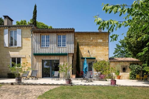 Gîte Les Petits Toits à Galgon : terrasse de maisons en pierre, coin détente et jardin