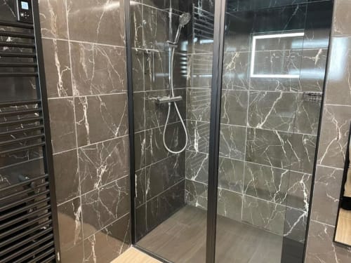 Salle de douche moderne avec carrelage effet marbre noir et accessoires chromés aux gîtes du grand saule à Tardinghen