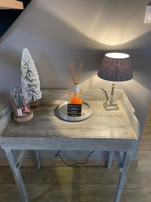 Table en bois blanchie à la chaux avec sapin blanc, diffuseur de parfum et lampe de table aux gîtes du grand