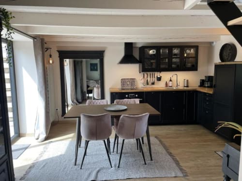 Cuisine et salle à manger de cottage moderne aux gîtes du grand saule à Tardinghen, avec armoires noires, table en bois et