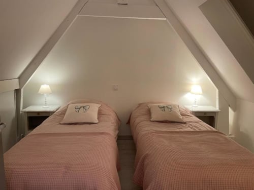 Deux lits simples avec literie rose dans une chambre mansardée des Gîtes du Grand Saule à Tardinghen, France