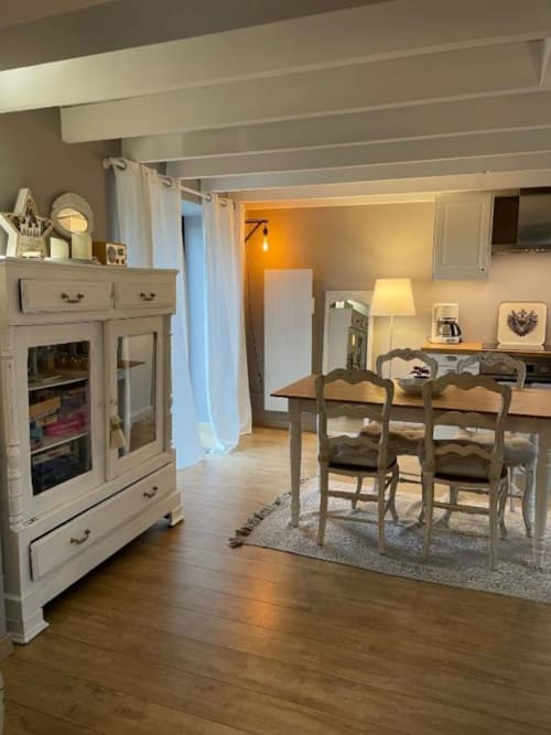 Salle à manger lumineuse avec table en bois, chaises, électroménagers et armoires crème aux gîtes du grand saule