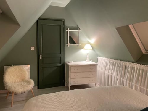 Chambre cosy sous les toits aux Gîtes du Grand Saule à Tardinghen avec plafonds mansardés, commode rose et vue sur le jardin