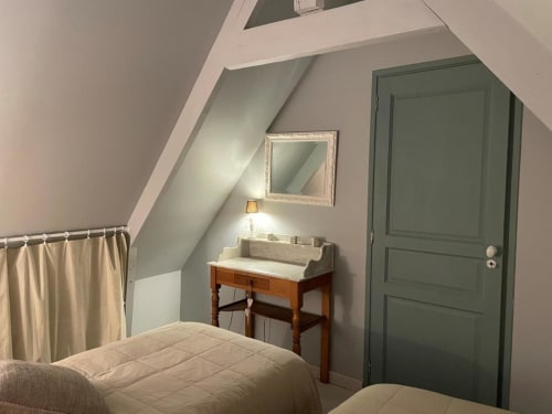 Chambre mansardée aux Gîtes du Grand Saule à Tardinghen avec lits jumeaux, bureau en bois et porte verte