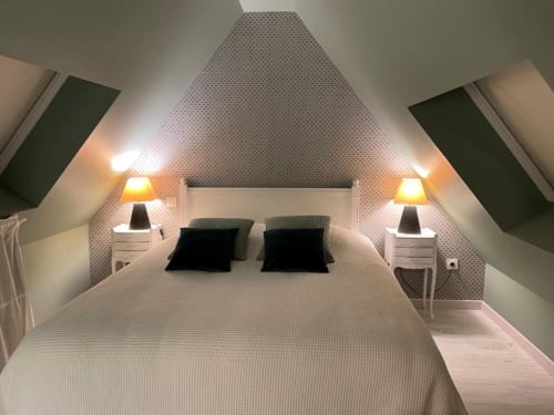 Chambre mansardée douillette aux gîtes du grand saule à Tardinghen avec lits jumeaux, éclairage chaleureux et papier peint à motifs