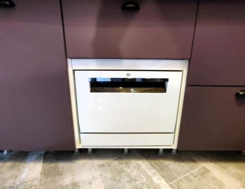 Lave-vaisselle blanc intégré avec poignée en acier inoxydable dans la cuisine moderne du loft Le Travertin, Avignon