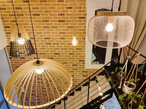 Luminaires suspendus modernes et plantes grimpantes dans le loft Le Travertin de l'hôtel Oriflamme à Avignon, avec murs en briques apparentes