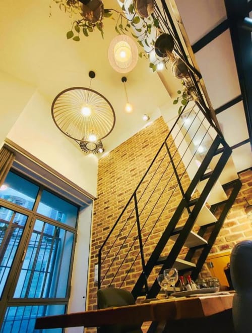 Escalier moderne du loft avec mur en briques, luminaires suspendus et plantes grimpantes à Oriflamme & Travertin, Avignon
