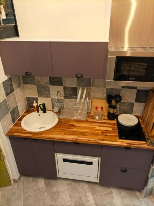 Kitchenette moderne à l'appartement Le Travertin Loft, Avignon, avec plan de travail en bois, placards violets, dosseret carrelé