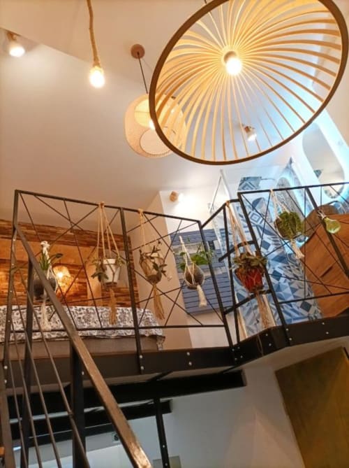 Escalier moderne de loft à Avignon avec luminaires géométriques et vue sur la ville par les fenêtres