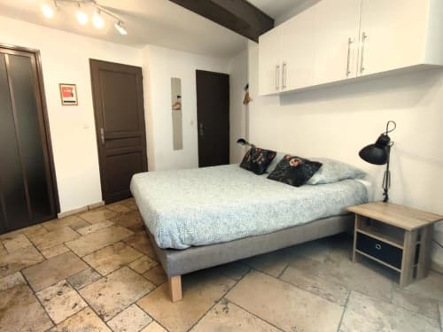Chambre studio moderne à Avignon avec lit double, kitchenette, carrelage et vue sur la ville - Oriflamme & Travertin