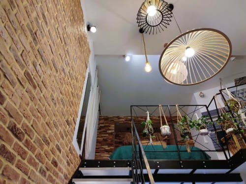 Intérieur de loft moderne à Oriflamme & Travertin, Avignon, avec murs en briques apparentes, éclairage suspendu et mezzanine
