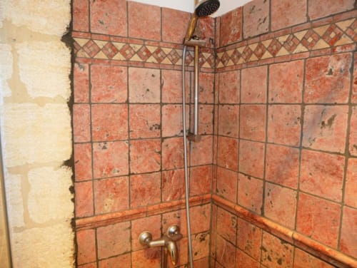 Salle de bains avec douche aux carrelages en terre cuite et équipements en laiton à l'appartement Oriflamme & Travertin à Avignon