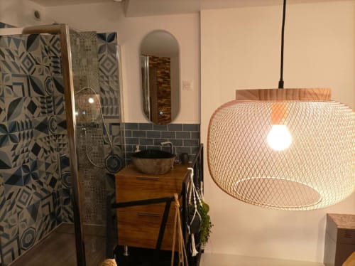 Salle de bains moderne du Loft Le Travertin à Avignon, avec meuble vasque bois, suspension et carrelage à motifs