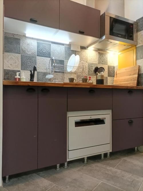 Cuisine moderne du loft Le Travertin à Avignon, avec placards marron, plan de travail en bois, crédence carrelée, four