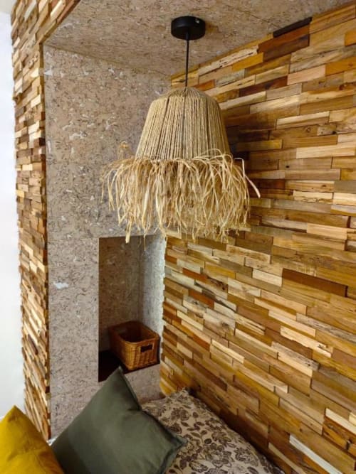 Coin douillet avec luminaire suspendu tissé, mur d'accent en bois et surfaces en béton dans le loft Le Travertin à Avignon