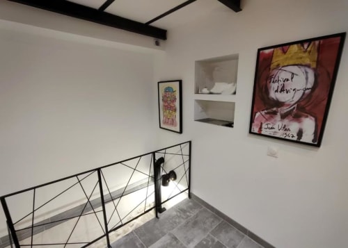 Cage d'escalier contemporaine du Loft Le Travertin à Avignon, avec œuvre d'art moderne et rampe géométrique.
