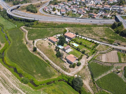 Vista aérea da Quinta de Carvalhal em Guimarães com jardins, piscina e paisagem de vinhedos circundantes