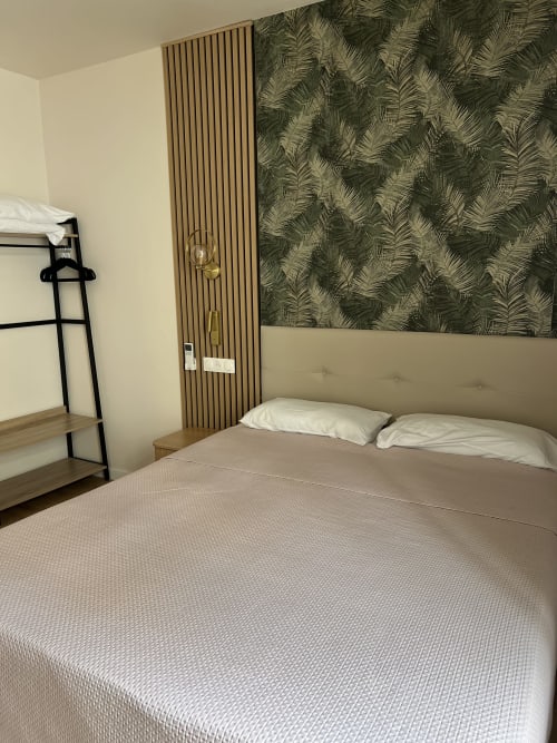 Chambre moderne aux Paquebots à Port-Vendres avec lit queen-size, papier peint fougère, lattes de bois et lits superposés