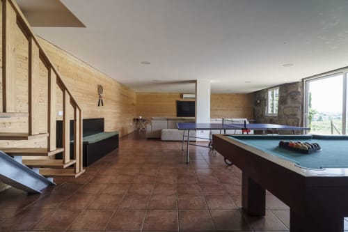Sala de recreação da Quinta de Carvalhal em Guimarães com bilhar, ping pong, detalhes em madeira e vista para o jardim
