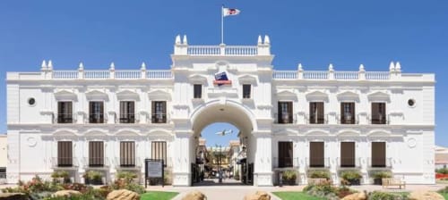 White colonial-style building entrance with arched gateway in Málaga, Spain