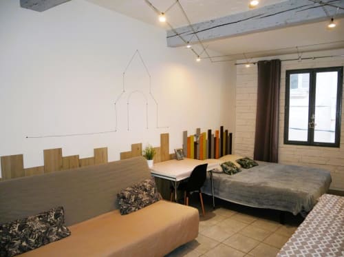 Chambre moderne à l'hôtel Oriflamme & Travertin avec plusieurs lits, bureaux en bois et art mural contemporain
