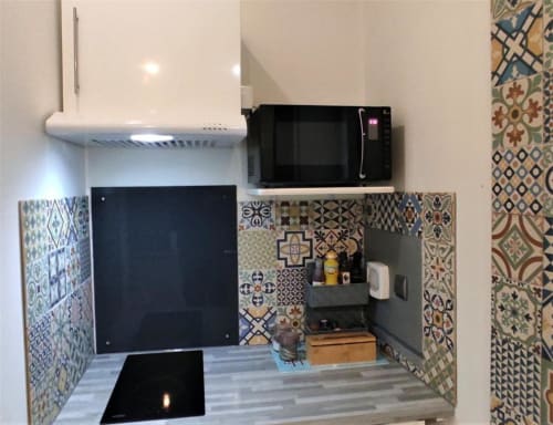 Kitchenette Studio Zoé à Avignon avec carrelage motifs, micro-ondes et cuisinière