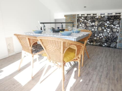 Séjour Sweet Cotton Duplex avec coin repas, chaises en rotin, cuisine ouverte et vue sur la ville à l'hôtel Oriflamme & Travertin d'Avignon