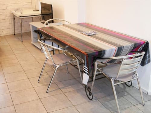 Coin repas Studio Théa avec table, textiles colorés et chaises métalliques dans un appartement avignonnais