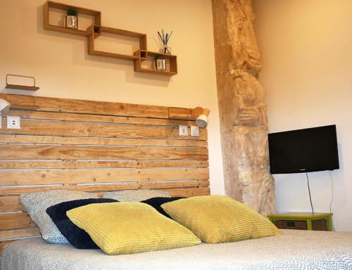 Chambre Studio Zoé à Oriflamme & Travertin Avignon avec lit en bois, oreillers jaunes, TV et poutre apparente