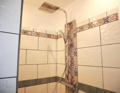 Salle de bain moderne aux carreaux métro crème, frise ornementale et douche vitrée à Studio Zoé, Avignon