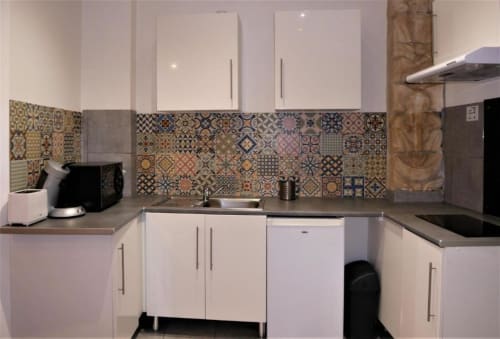 Cuisine moderne du Studio Théa à Oriflamme & Travertin, Avignon, avec armoires blanches et carrelage à motifs