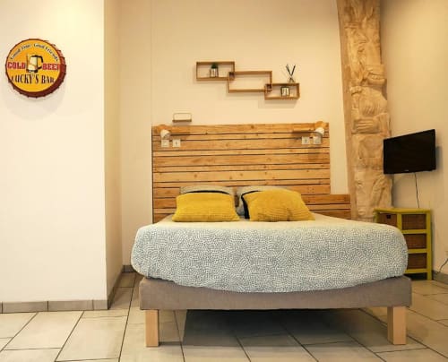 Chambre Studio Zoé à Oriflamme & Travertin, Avignon, avec tête de lit en bois, oreillers jaunes et TV écran plat