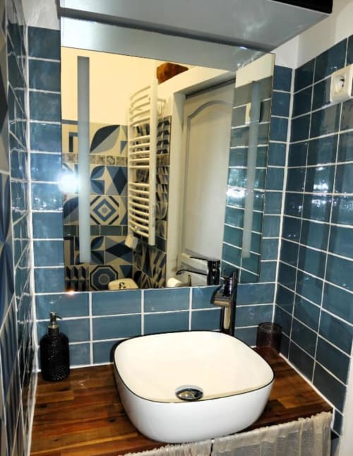 Lavabo moderne de la Studio Théa, hôtel Oriflamme & Travertin à Avignon, avec carrelage turquoise et miroir décoratif.