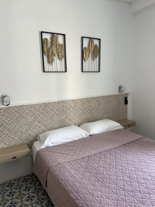 Chambre moderne de l'Hôtel Les Paquebots à Port-Vendres avec lit queen-size, tête de lit géométrique et décoration murale à feuille d'or