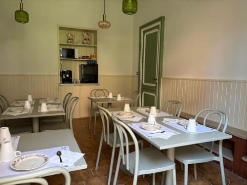 Sala da pranzo del ristorante Il 900 di Avezzano con tavoli preparati, lampadari a sospensione e porta verde