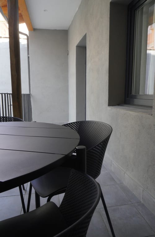 Área de descanso moderna en la terraza del Palacio Mambrilla Valladolid con sillas negras y mesa con vistas a la ciudad