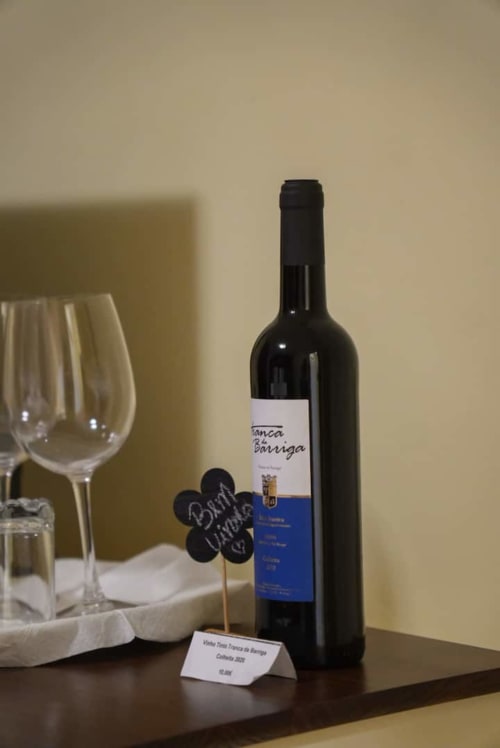 Garrafa de vinho com rótulo na Tranca da Barriga Casa do Vinho, refúgio aconchegante português dedicado aos amantes de vinho