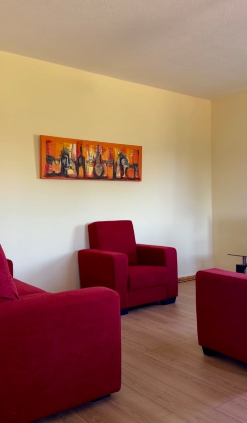 Sala de estar moderna com poltronas vinho na Tranca da Barriga Casa do Vinho, uma casa de hóspedes temática de vinho português