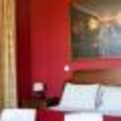 Quarto vermelho com roupa de cama branca na Tranca da Barriga Casa do Vinho, Dominguiso Portugal