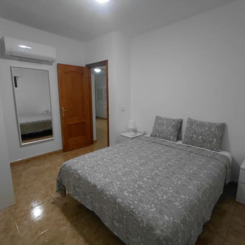 Dormitorio espacioso en My Little Bungalow con cama doble, puertas de madera, aire acondicionado y comodidades modernas en El Palm-Mar