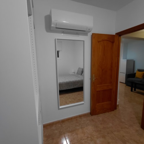 Entrada moderna de dormitorio en My Little Bungalow con espejo, aire acondicionado y puerta de madera en El Palm-Mar