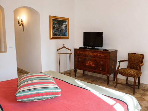 Chambre double élégante à l'Auberge du Parc, Correns, avec literie rouge, mobilier ancien et vue sur jardin