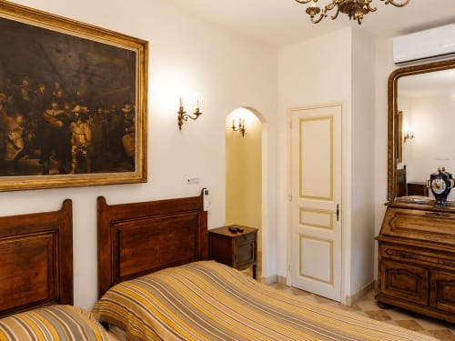 Élégante chambre double à l'Auberge du Parc à Correns avec mobilier bois, literie rayée et décor classique