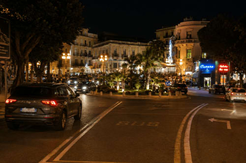 Piazza de Reggio Calabria la nuit avec élégants bâtiments, palmiers et lampadaires près de la Guest House B&B Pellicano