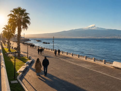 Promenade balnéaire à Reggio Calabria avec palmiers, l'Etna en arrière-plan, et visiteurs se promenant sur le sable